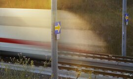 Two blue signals to the right and left of a track, each with yellow arrows pointing to tracks