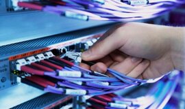 Person plugs network cable into data center Person plugs network cable into data center
