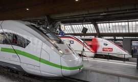 Drei Hochgeschwindigkeitszüge stehen in einem Bahnhof.