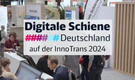 Foto eines Messestandes mit zwei Bildschirmen, vielen Besuchenden, einer Beachflag im Hintergrund mit dem Digitale Schiene Logo. Im Vordergrund des Fotos steht: "Digitale Schiene Deutschland auf der InnoTrans 2024"