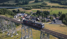 Der Testzug des Moving Block Demonstrators fährt über eine Brücke im Digitalen Testfeld Bahn im Erzgebirge. | © DB InfraGO