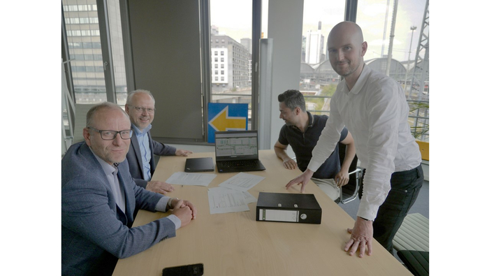 Board member, Klaus Müller, overall project manager, Ulrich Kohlenberger, Head of Commercial Project Management of the Rhine-Alpine corridor, Robert Amrey, and contract manager, Mehran Ataie at a table (Copyright: DB InfraGO AG/Digitale Schiene Deutschland, Harald Heusner)
