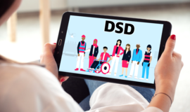 Eine Frau hält ein Tablet in der Hand. Zu sehen ist das Deckblatt des abzuspielenden Videos. 