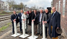 Protagonist:innen stehen vor dem Stellwerk Kempen um einen Signalschirm und „schalten“ diesen auf Grün