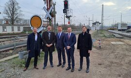 V.l.n.r.: Gabor von Wilmowski (DB Netz AG), Markus Fritz (Thales Deutschland GmbH), Bahnchef Dr. Richard Lutz, Bundesverkehrsminister Dr. Volker Wissing, Frank Gülicher (Deutsche Bahn AG) (Quelle: DB Netz AG/Martin Siegesmund) stehen vor Gleisen und einigen Signalen.