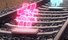 Neon leuchtende Hashtags über einer ETCS Balise in einem Gleis. Neon leuchtende Hashtags über einer ETCS Balise in einem Gleis.
