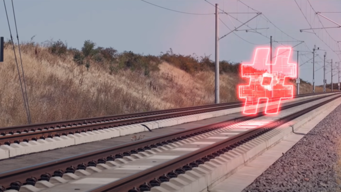 A neon red hashtag floating on top of rails.