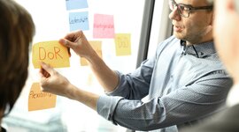 3 people placing and looking at postits on a window. 3 people placing and looking at postits on a window.