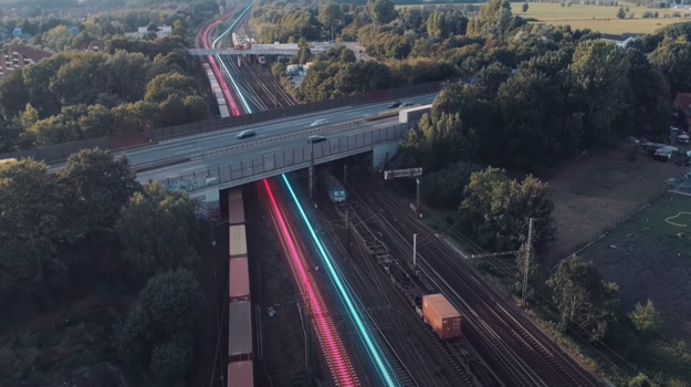 Hier sehen Sie ein Stimmungsbild der Digitalen Schiene Deutschland mit Gleisen und einer Brücke, die über die Gleise führt.