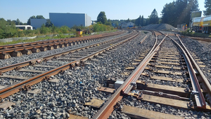 Foto zeigt dreigleisige Strecke im Sonnenschein. Sicht vom Gleis auf die beiden linken Gleise