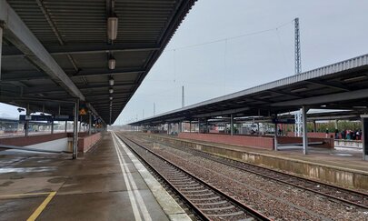 Auf dem Bild sieht man den Bahnsteige des Bahnhofs Schönefeld an einem verregneten Tag.