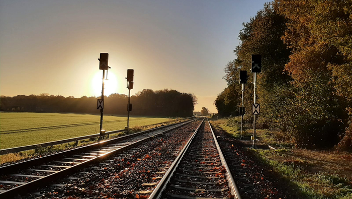 Bahnstrecke im Sonnenaufgang mit den neuen Signalen.