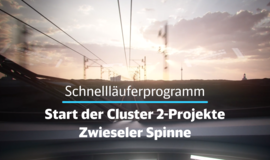 Bahnübergang mit Oberleitungen zu sehen. Die Sonne geht gerade unter. Im Vordergrund des Bildes steht: Schnellläuferprogramm, Start der Cluster-2-Projekte, Zwieseler Spinne Bahnübergang mit Oberleitungen zu sehen. Die Sonne geht gerade unter. Im Vordergrund des Bildes steht: Schnellläuferprogramm, Start der Cluster-2-Projekte, Zwieseler Spinne