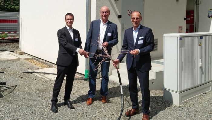 Andre Rodenbeck (CEO Rail Infrastructure at Siemens Mobility), Uwe Kober (Mayor of Altena) and Jens Bergmann (Board Member for Finance and Controlling at DB InfraGO AG) in front of the new interlocking module in Altena (Source DB InfraGO AG/Philipp Bockholt)