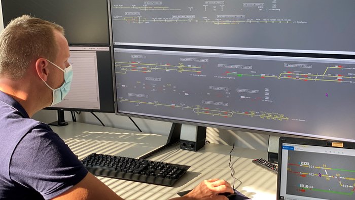 A person sitting in front of two very long screens, covering almost all of the picture.